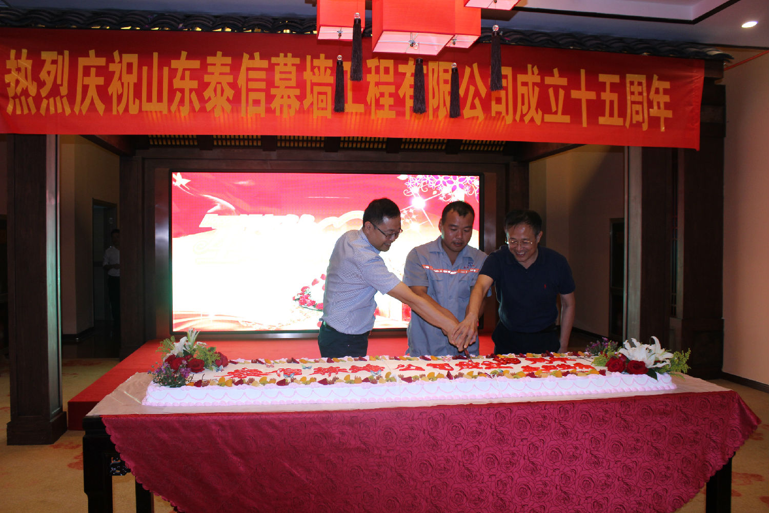 杜总、刘先生和与公司同天过生日的一位同事共同切开泰信的生日蛋糕
